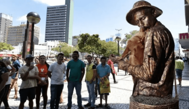 Cachorra ajuda o tutor como “estátua viva” e encanta turistas 