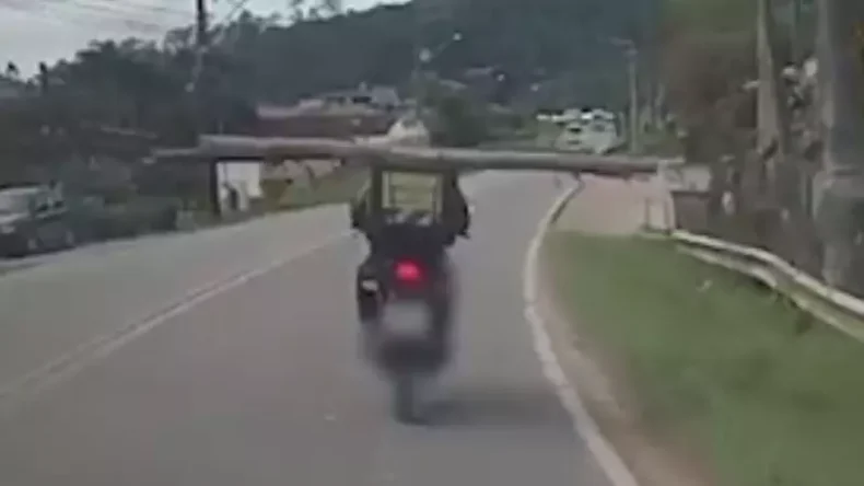 Vídeo: motociclista é flagrado transportando um tronco de árvore