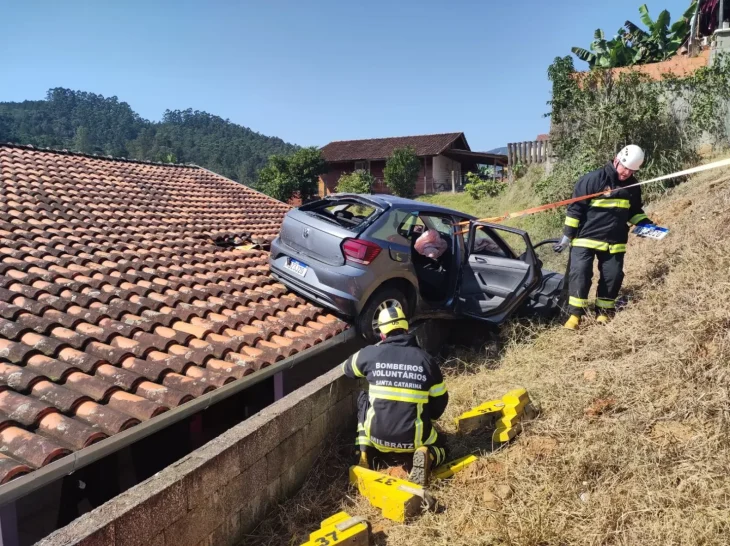 Idosa perde controle da direção e carro vai parar no telhado