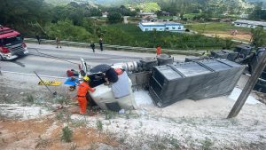 Motorista fica preso às ferragens após caminhão bitrem tombar