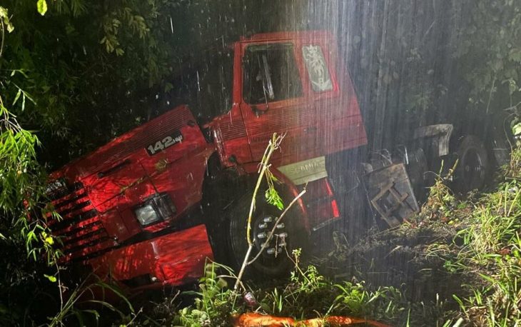 Motorista fica preso após carreta tombar em temporal na BR-470