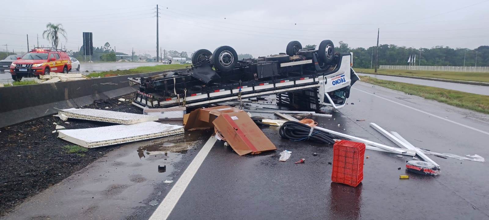 Caminhão capota na BR-101 e para com as rodas para cima na pista contrária