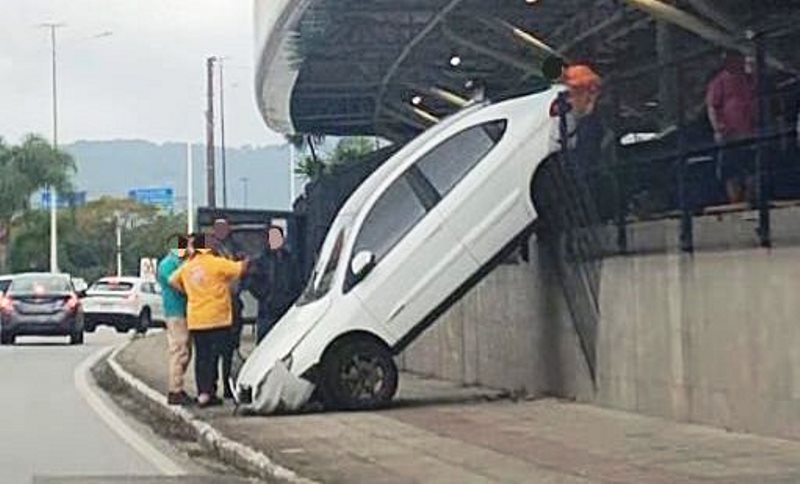 Manobra desastrosa: carro derruba grade de estacionamento e cai “de bico” na calçada