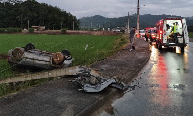 Motorista sobrevive após carro bater em poste e capotar