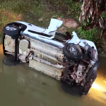 Carro cai em riacho com família dentro e motorista foge do local