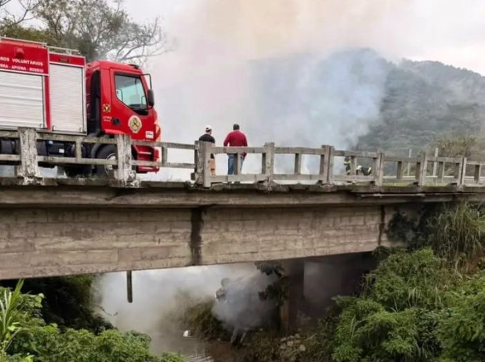 Carro sai da pista, cai em ponte e é destruído pelo fogo na BR-470