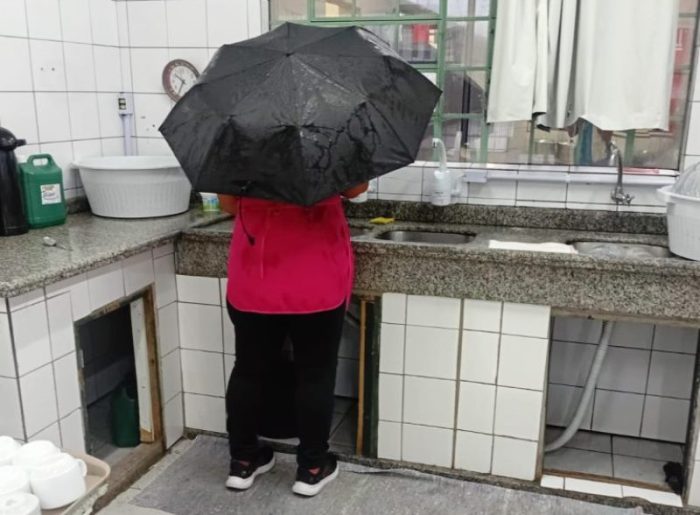Merendeira usa guarda-chuva em refeitório por causa das goteiras em SC